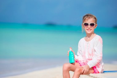 Güneş kremi tropik sahilde şişe güzel çocuk