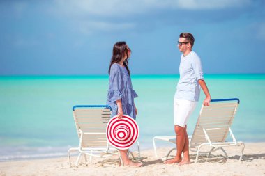 Karayipler 'deki Antigua adasında beyaz kum ve turkuaz okyanus suyuyla tropikal plajda genç bir çift.