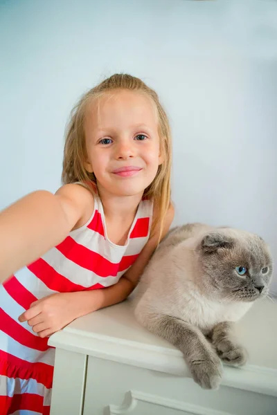Sevimli küçük kız evde onun evcil hayvan kedi öpüşme. Çocuk ve hayvan aşk — Stok fotoğraf