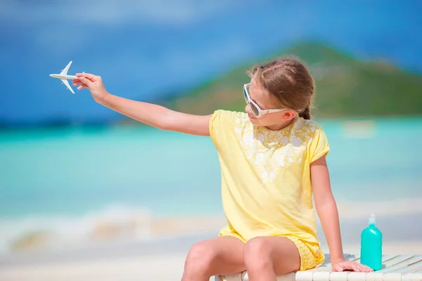 Niña feliz con avión de juguete en las manos en la playa de arena blanca. — Foto de Stock