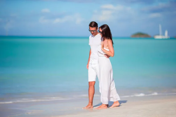 Jong koppel lopen op tropische Carlisle baai strand met wit zand en turquoise oceaanwater op Antigua island — Stockfoto