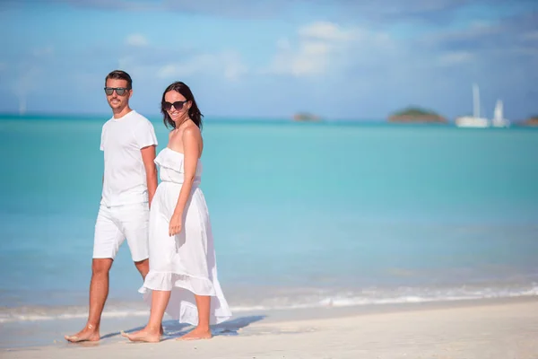 Giovane coppia che cammina sulla spiaggia tropicale della baia di Carlisle con sabbia bianca e acqua turchese sull'isola di Antigua — Foto Stock