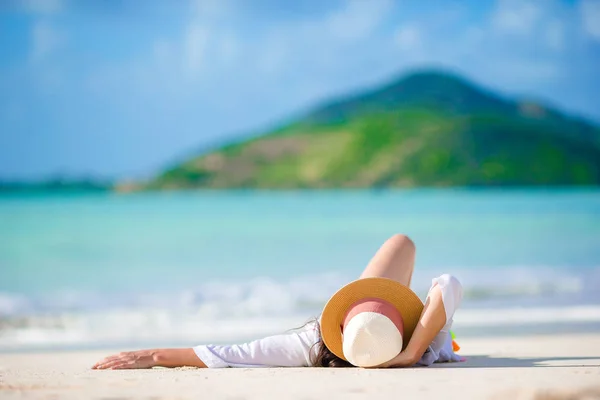 Jovem mulher desfrutando do sol banhos de sol pelo perfeito oceano azul-turquesa — Fotografia de Stock