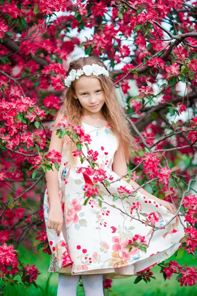 Imádnivaló kislány a virágzó almafakertben tavasszal — Stock Fotó
