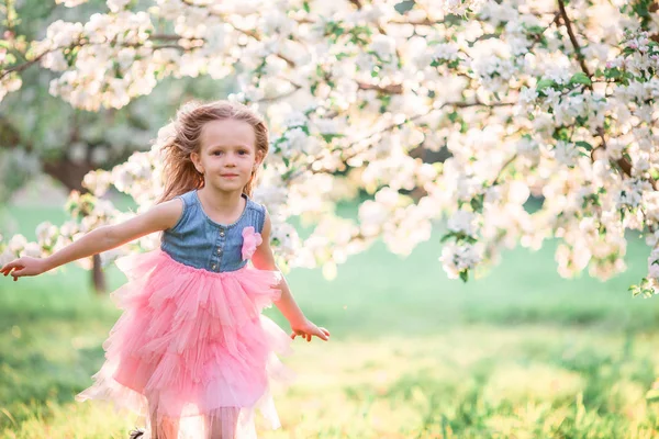 Adorabile bambina che si gode la giornata di primavera nel giardino fiorito di mele — Foto Stock