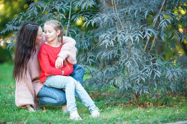 Bedårande liten flicka med ung mamma i blommande trädgård vårdag — Stockfoto