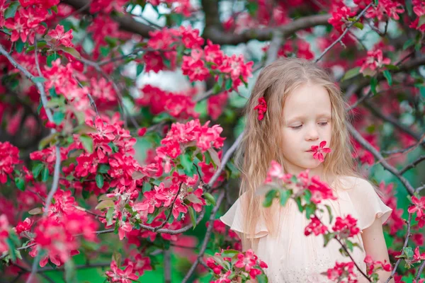 Adorable niña disfrutando del día de primavera en el jardín floreciente de manzana —  Fotos de Stock