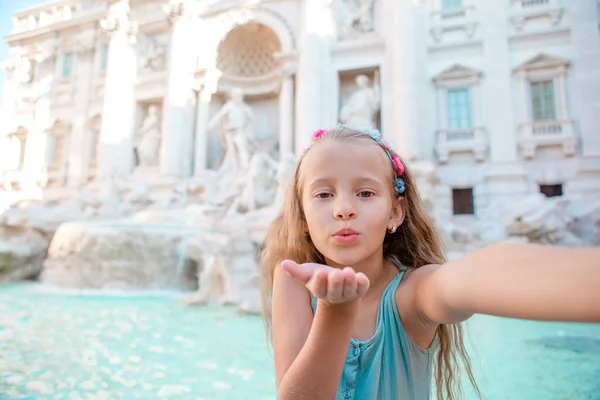 Adorable niña tomando selfie junto a la Fuente de Trevi en Roma . —  Fotos de Stock
