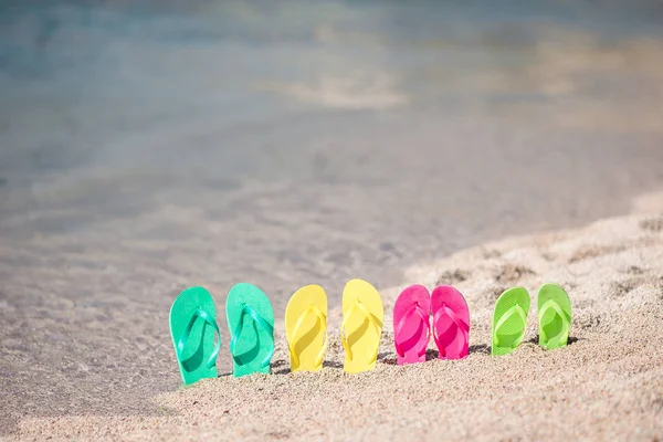 Familie bunte Flip-Flops am Strand vor dem Meer — Stockfoto