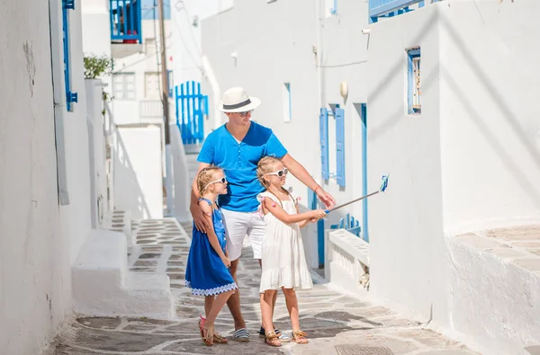 Отец и дети делают селфи фоне города Миконос в Греции — стоковое фото