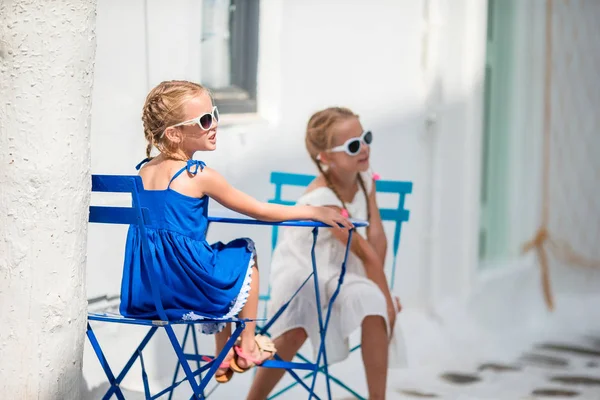 Dos chicas en vestidos azules divirtiéndose al aire libre en las calles de Mykonos — Foto de Stock