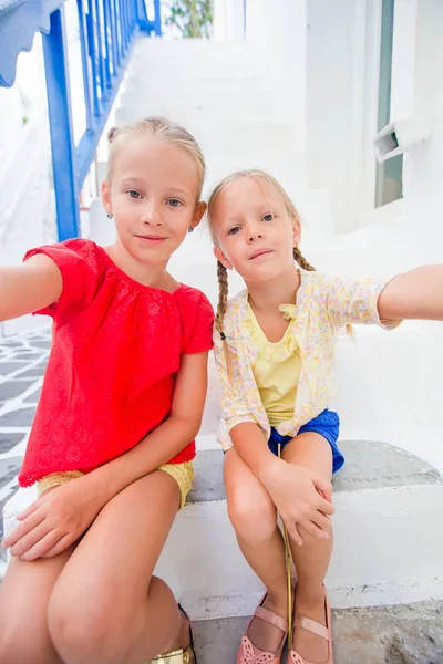两个女孩在户外玩乐麦克诺斯岛街道上的蓝色连衣裙 — 图库照片