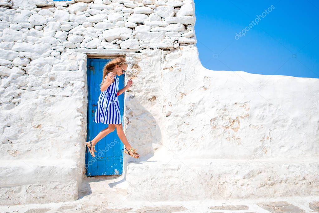 Girl in blue dresses having fun outdoors on Mykonos streets