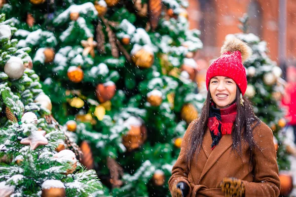 Lykkelig pige nær grantræ gren i sne til nytår. - Stock-foto