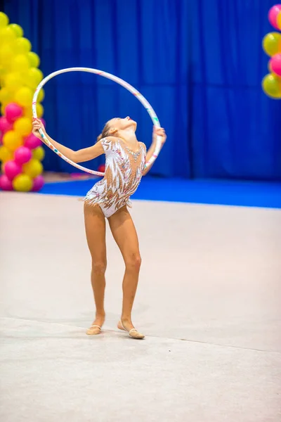 Красивая маленькая гимнастка на ковре на соревнованиях — стоковое фото
