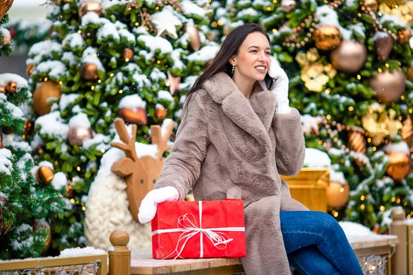 La muchacha feliz cerca de la rama del abeto en la nieve para un nuevo año. —  Fotos de Stock