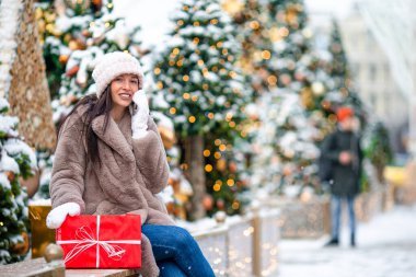 Mutlu kız yılbaşı için karların içinde köknar ağacı dalının yanında.