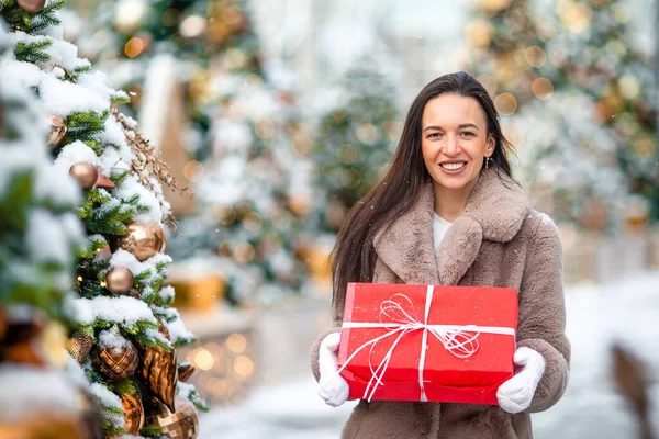 La muchacha feliz cerca de la rama del abeto en la nieve para un nuevo año. —  Fotos de Stock