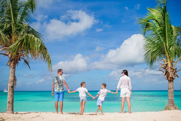 Счастливая красивая семья из четырех человек на пляже — стоковое фото