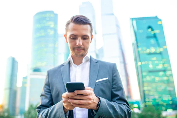 Joven hombre caucásico sosteniendo smartphone para el trabajo de negocios . —  Fotos de Stock