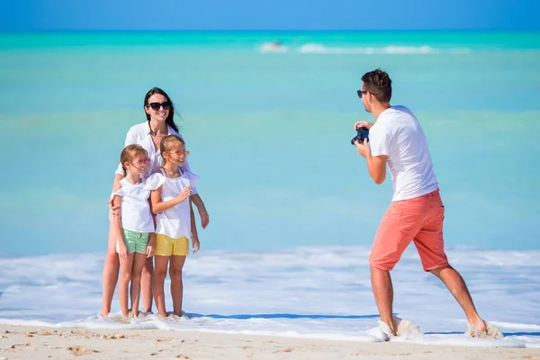 Семья из четырех человек делает селфи во время пляжного отдыха. Семейный отдых на пляже — стоковое фото