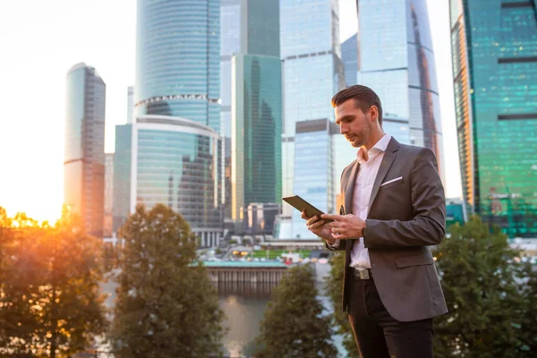 Joven hombre caucásico sosteniendo smartphone para el trabajo de negocios . — Foto de Stock