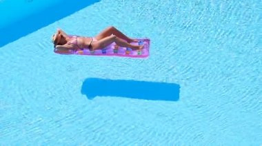 Büyük yüzme havuzunda bikini hava şilte genç kadın