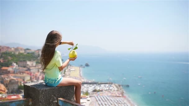 Grande limone giallo in mano sullo sfondo del Mar Mediterraneo e del cielo . — Video Stock