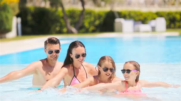 Happy family of four in outdoors swimming pool — Stock Video