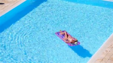 Büyük yüzme havuzunda bikini hava şilte genç kadın
