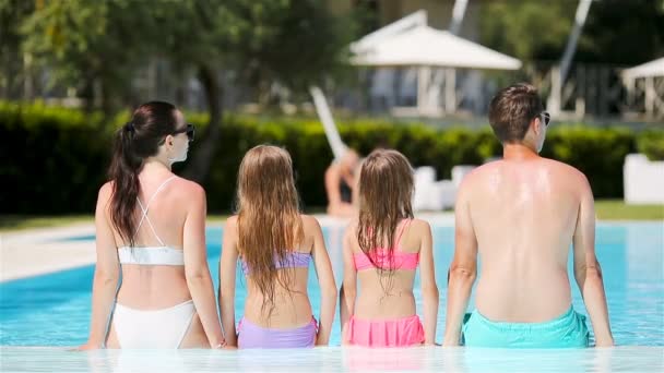 Familia feliz de cuatro en la piscina — Vídeo de stock