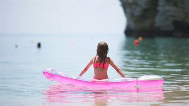 Adorable girl on inflatable air mattress in the sea — Stock Video