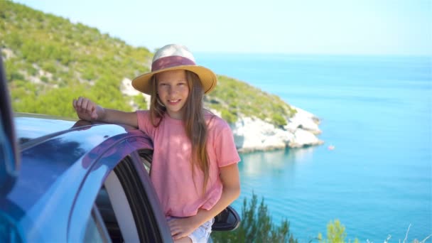 Liten flicka på semester resor med bil bakgrunden vackra landskap — Stockvideo