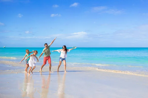 En lykkelig familie på fire på stranda. – stockfoto