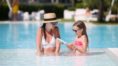 Genç kızın burnuna sahilde uygulanan güneş kremi anne.