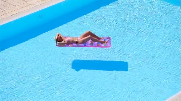 Giovane donna in bikini materasso ad aria nella grande piscina — Video Stock