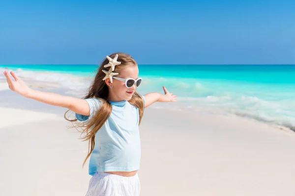 Vacker liten flicka i klänning på beach har roligt. Rolig tjej njuta av sommarlovet. — Stockfoto