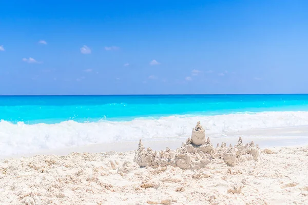 Песчаный замок на белом тропическом пляже с пластиковыми игрушками для детей — стоковое фото