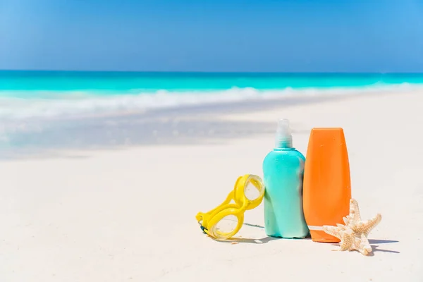 Solbränna lotion flaskor och sjöstjärna på stranden — Stockfoto