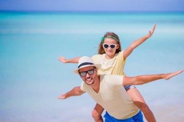 Küçük kız ve mutlu baba kumsal tatili boyunca eğleniyorlar.