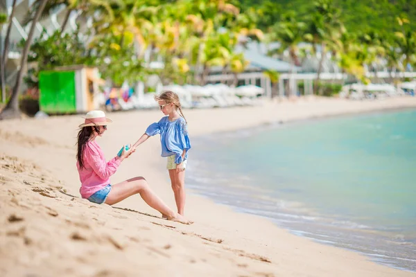 Young mother applying sunscreen on her daughter — Stock Photo, Image