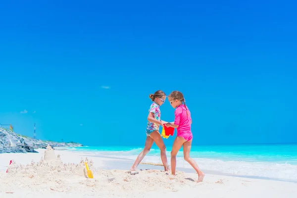 Two little happy girls have a lot of fun at tropical beach playing together — Stock Photo, Image