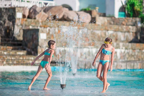 Adoráveis meninas brincando na piscina ao ar livre — Fotografia de Stock