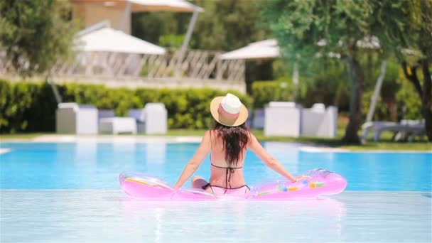 Jovem mulher em biquíni colchão de ar na grande piscina — Vídeo de Stock