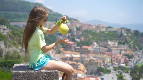 Big yellow lemon in hand in background of mediterranean sea and sky. — Stock Video