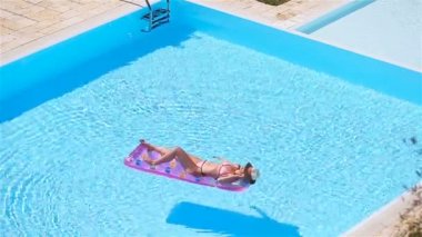 Güzel genç bayan yüzme havuzunda dinleniyor..