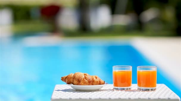 Delicioso desayuno limón, café, croissant junto a la piscina — Vídeos de Stock