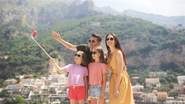 Szülők és gyerekek, hogy szelfi fotó háttér Positano város Olaszországban az Amalfi tengerparton — Stock videók