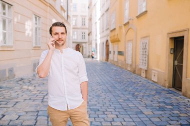 Genç adam eski Avrupa şehrinin özçekimini yapıyor.