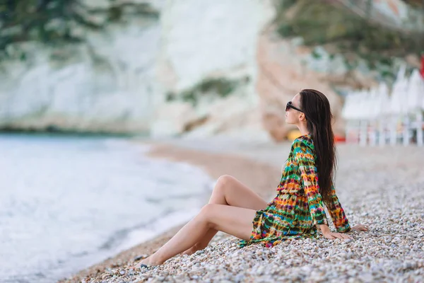 Plajda uzanan kadın yaz tatilinin tadını çıkarıyor ve denize bakıyor. — Stok fotoğraf